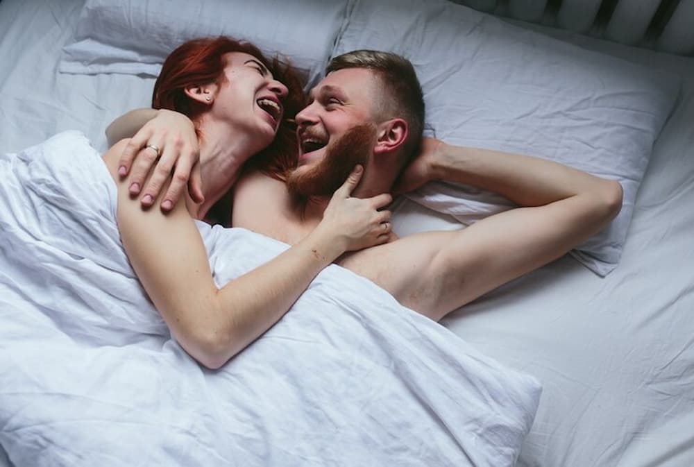 Pareja sonriente en la cama