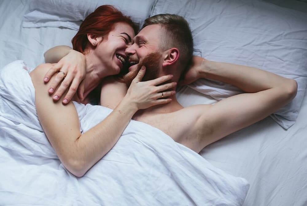 Pareja sonriente en cama